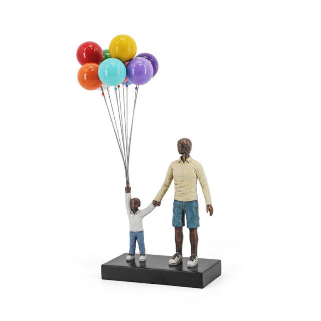 Statue of a man and child holding colorful balloons on a white background