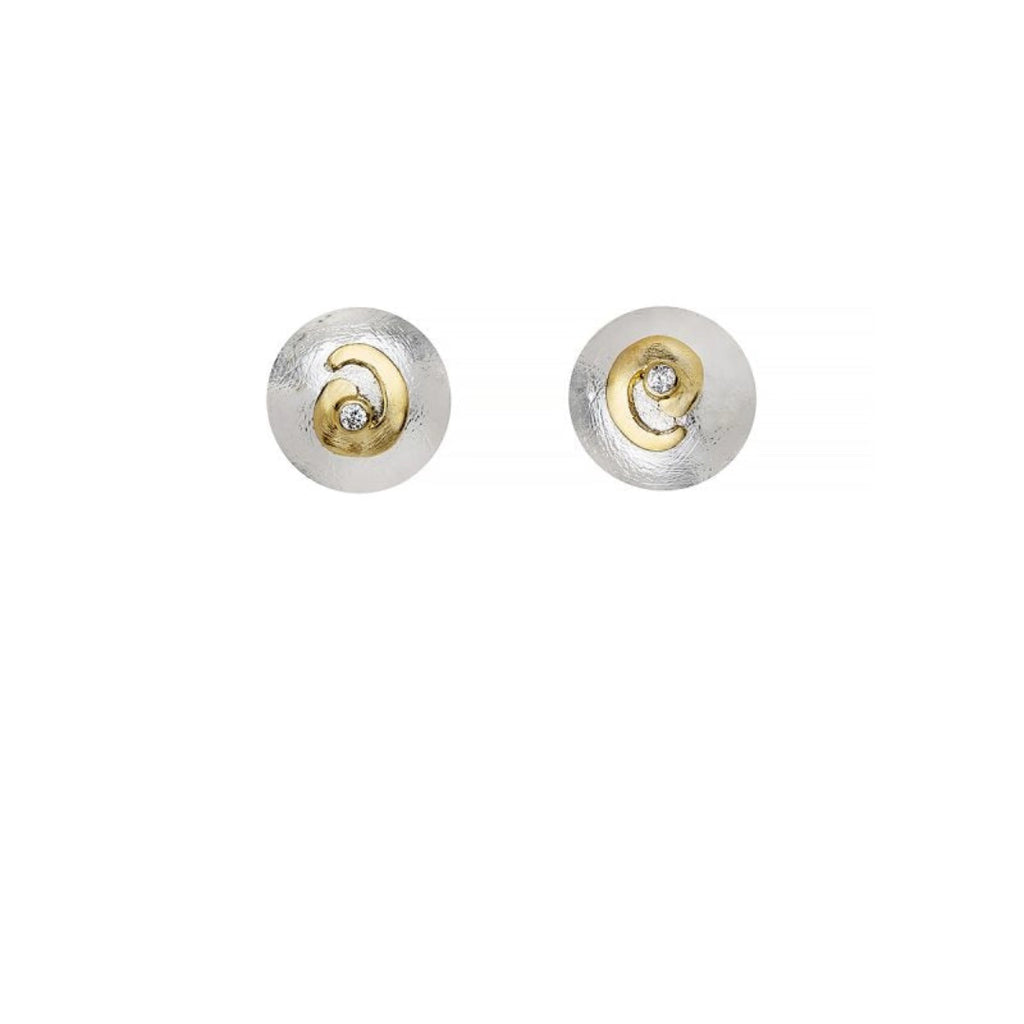 A pair of round stud earrings with textured silver-toned outer discs and a central gold-toned spiral detail holding a small clear gemstone, shown on a plain white background.